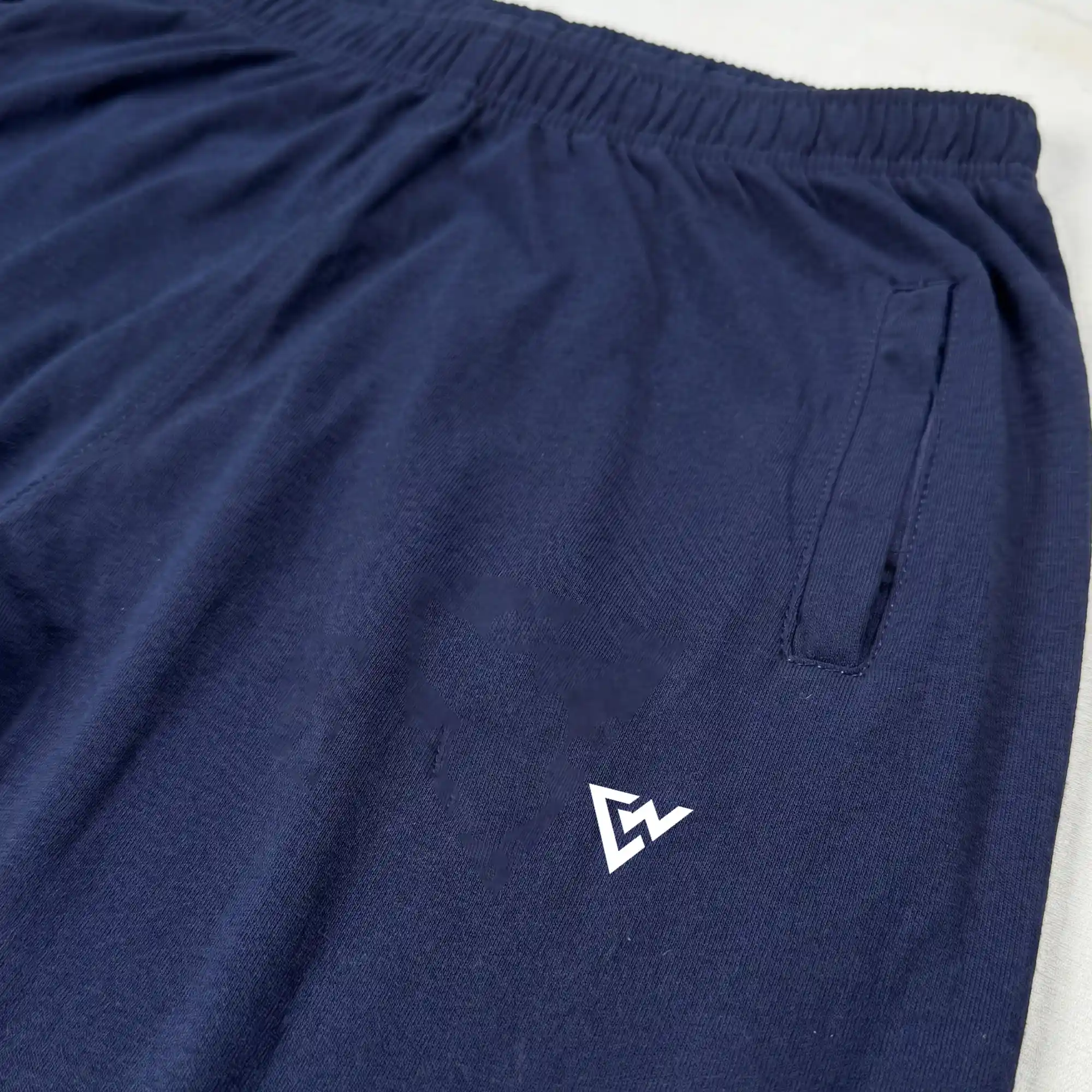 Navy blue trousers featuring elastic waistband and side pocket detail