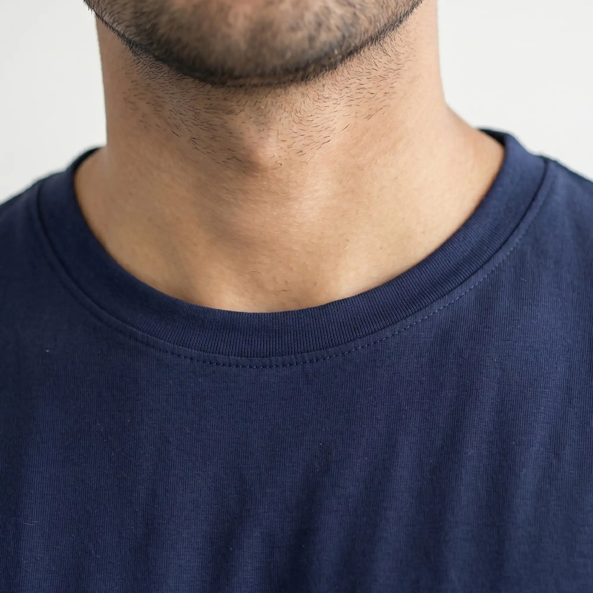 Close-up view of navy blue crew neck t-shirt collar stitching